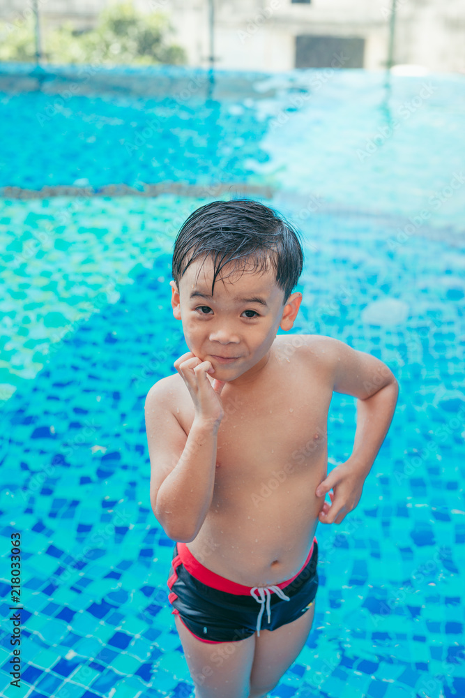 Stress Asian boy scratching his face on pool background. Summer concept