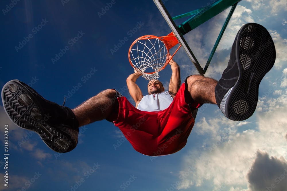 Low Angle View of Man Hanging on Basketball Hoop