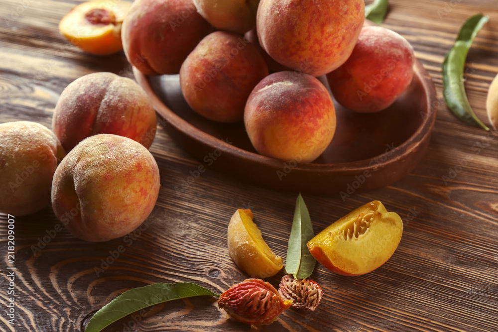 Plate with fresh peaches on wooden table, closeup