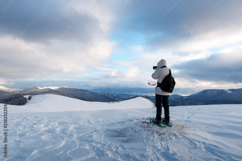 冬天独自一人背着背包在暴风雪中山顶拍摄。旅行理念。鲤鱼