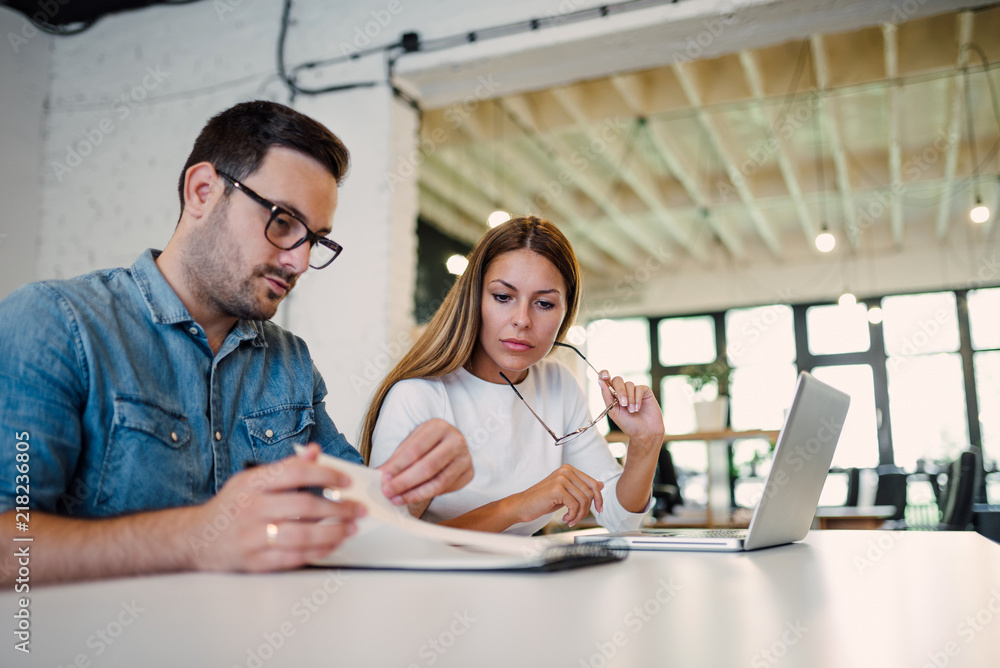 Two concentrated business colleagues working in bright office.