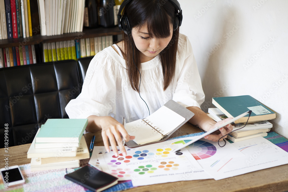 タブレット片手に勉強をしている女性