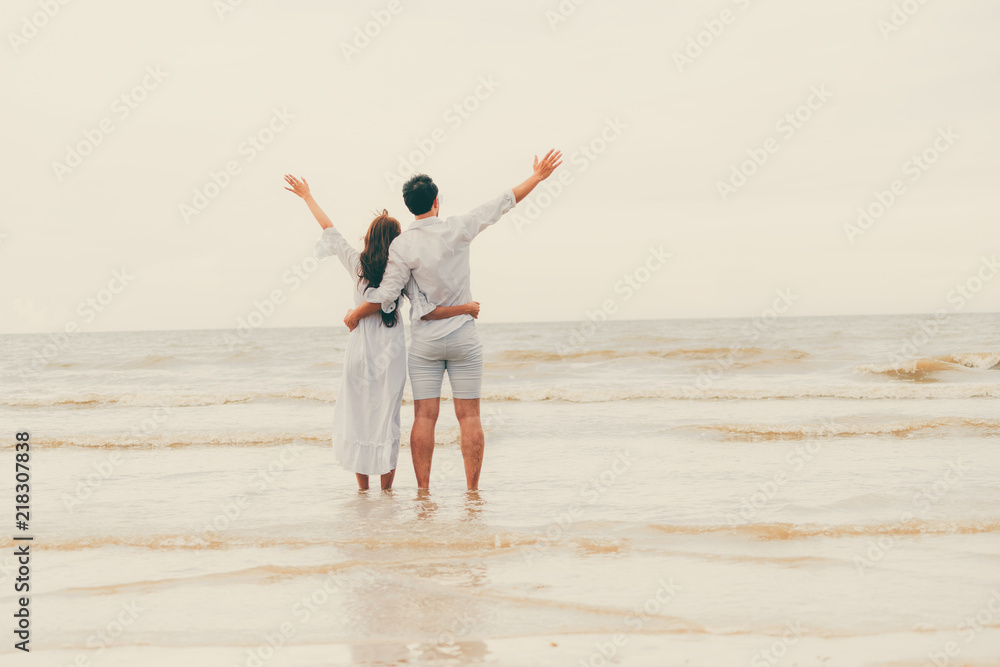 Couple going honeymoon on tropical beach in summer