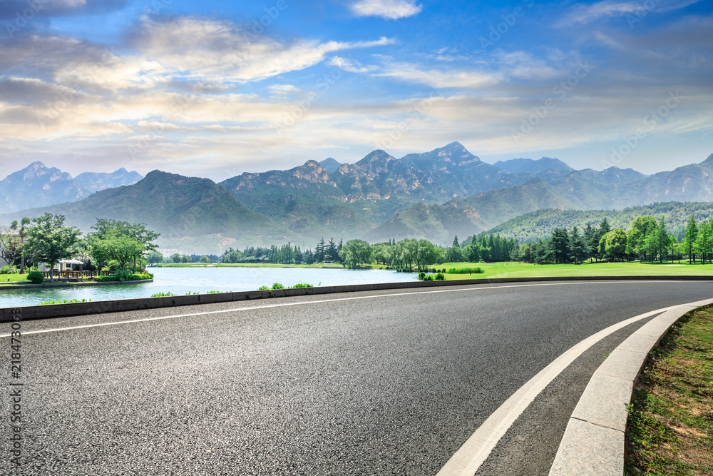 空旷的柏油公路和日落时的青山自然景观