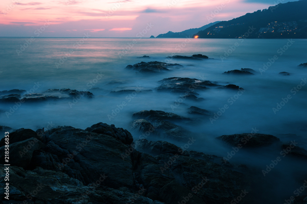 以岩石为背景的戏剧性天空海景的长曝光图像。