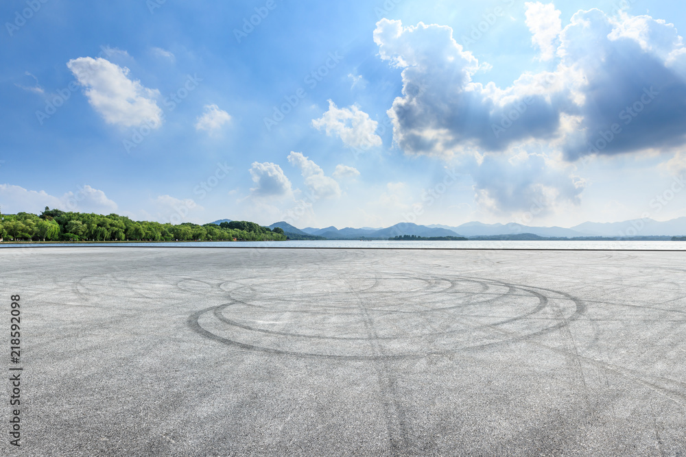 Empty asphalt square and mountain with lake on a sunny day