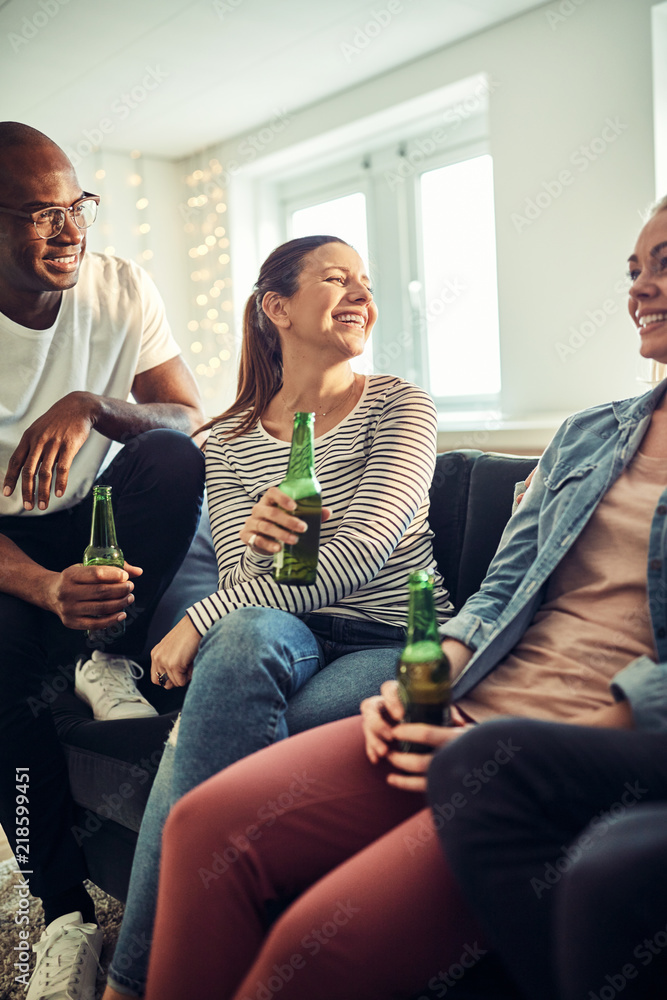 Young businesspeople laughing and drinking beers in an office