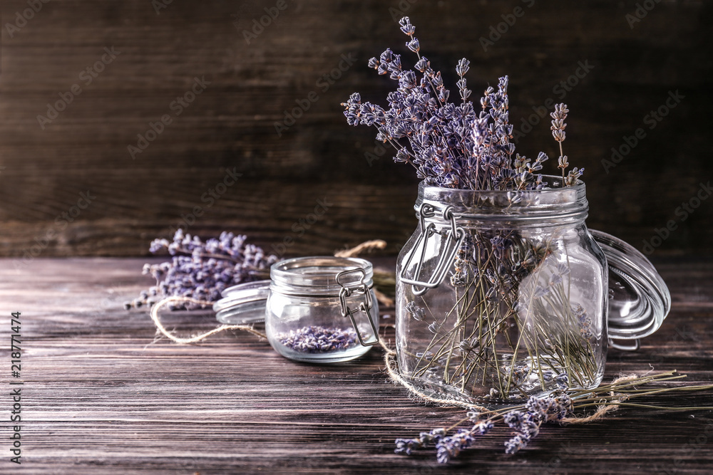 Glass jars with beautiful lavender flowers on wooden table