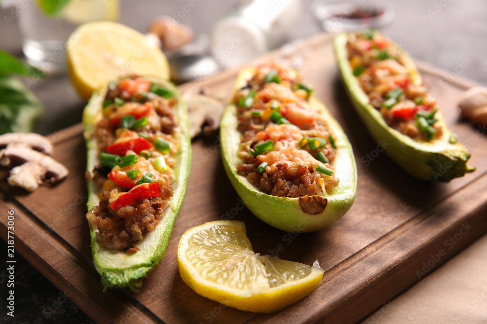 Meat stuffed zucchini boats on board, closeup