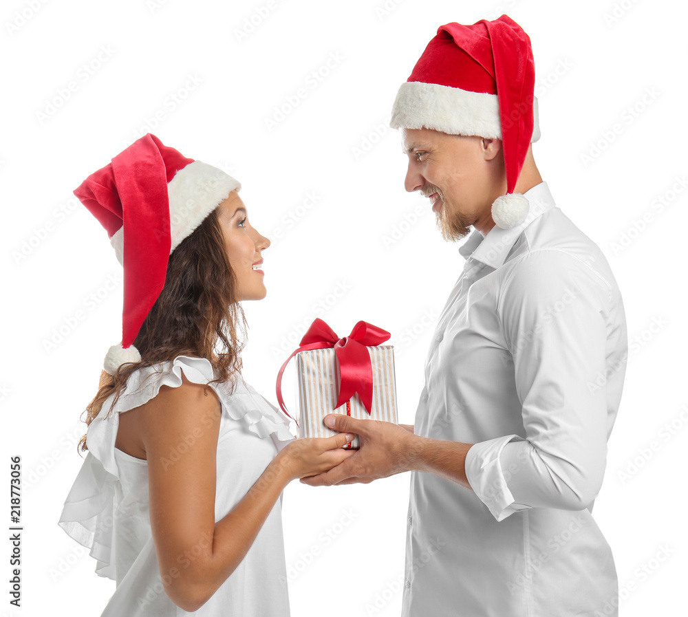 Portrait of cute young couple with Christmas present on white background