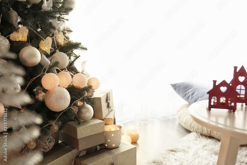 Beautiful decorated fir tree with gifts in room