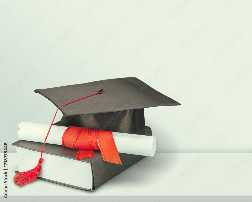 Graduation mortarboard on book on  background