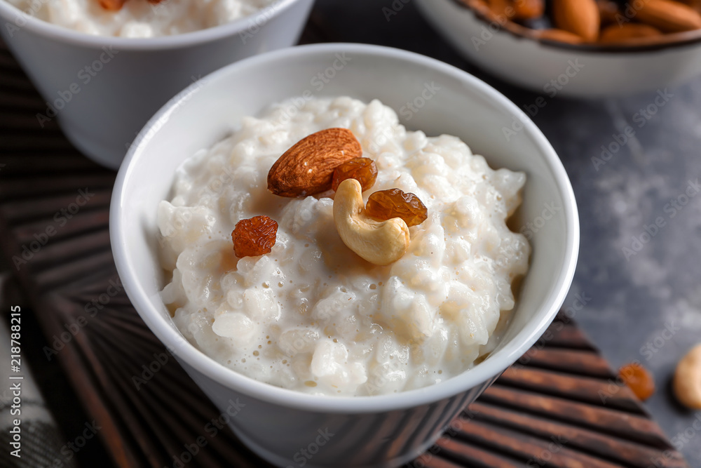 美味的米饭布丁配坚果和葡萄干，放在木板上的碗里，特写