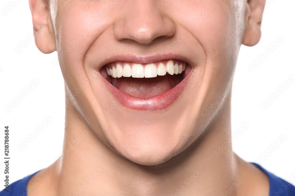 Young man with healthy teeth smiling on white background, closeup