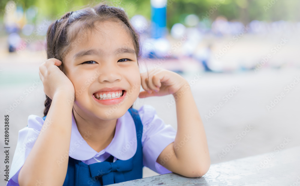 一个穿着制服的女学生站在花园旁的肖像