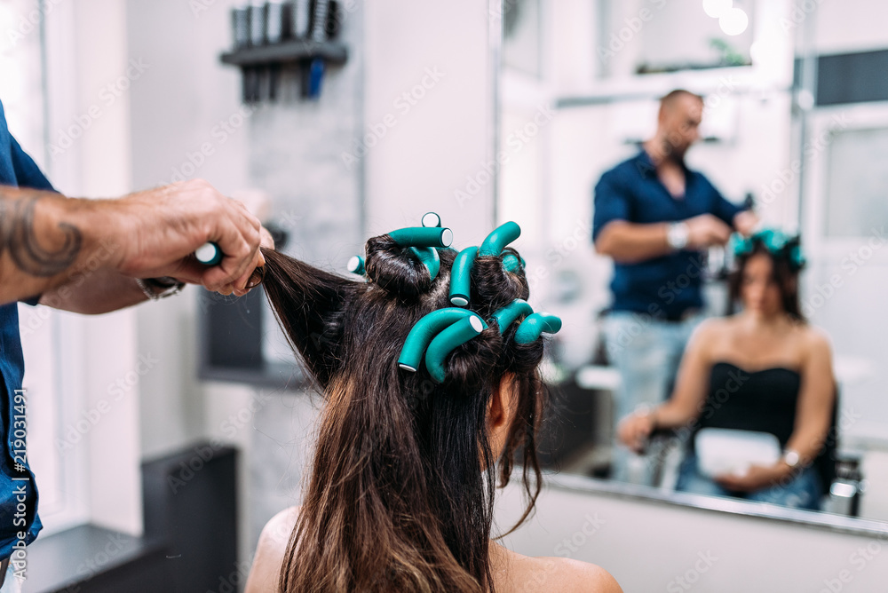 Making hairstyle to girl in beauty salon.