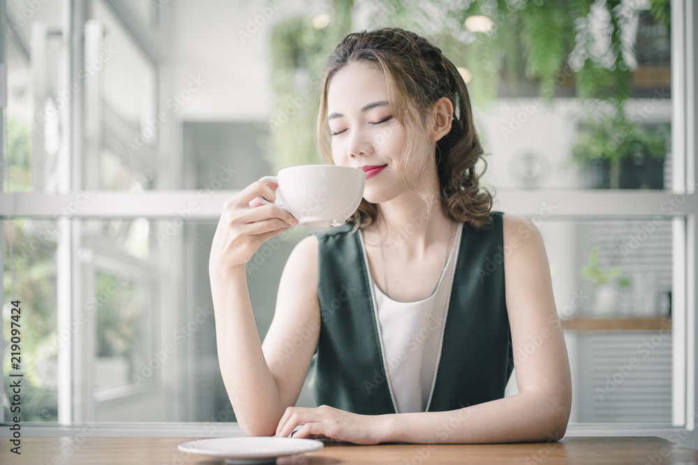 美丽的亚洲女孩早上喝一杯咖啡