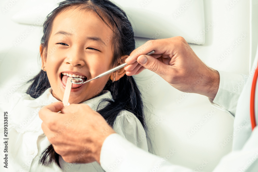 Dentist examining child teeth in dental clinic.