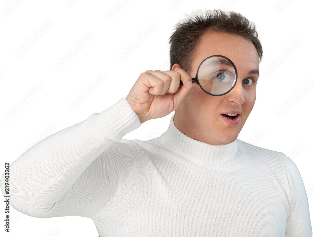 Portrait of young businessman with magnifying glass in white