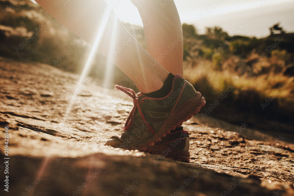 Female trail runner standing in sunlight