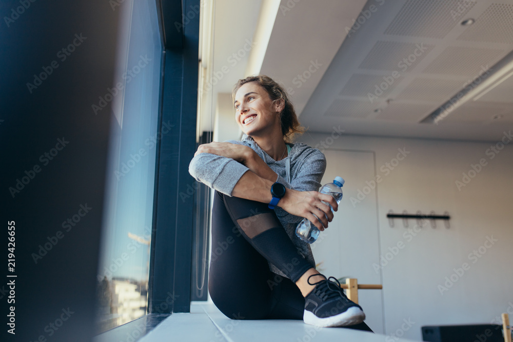 Woman relaxing after workout sitting in a pilates gym