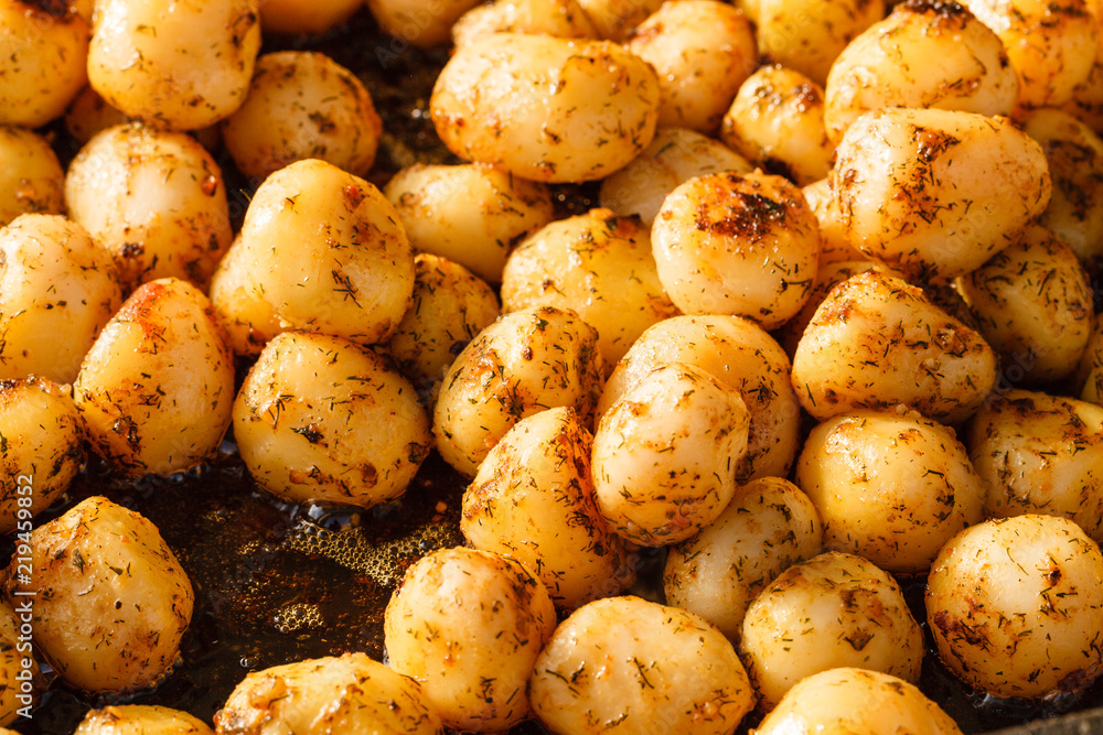 Backed young potatoes with spices in bowl