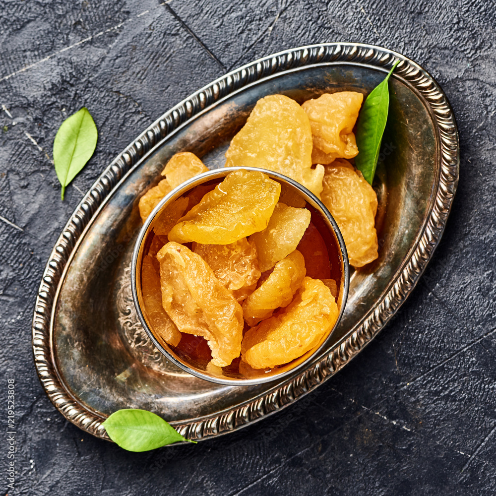 Dried pear, apricot or peach on black background. Top view of candied fruits.