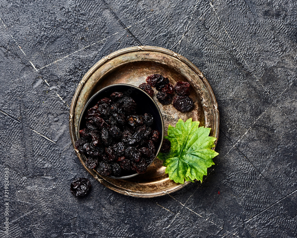 Dried cherry in bowl on black background. Top view of berries.