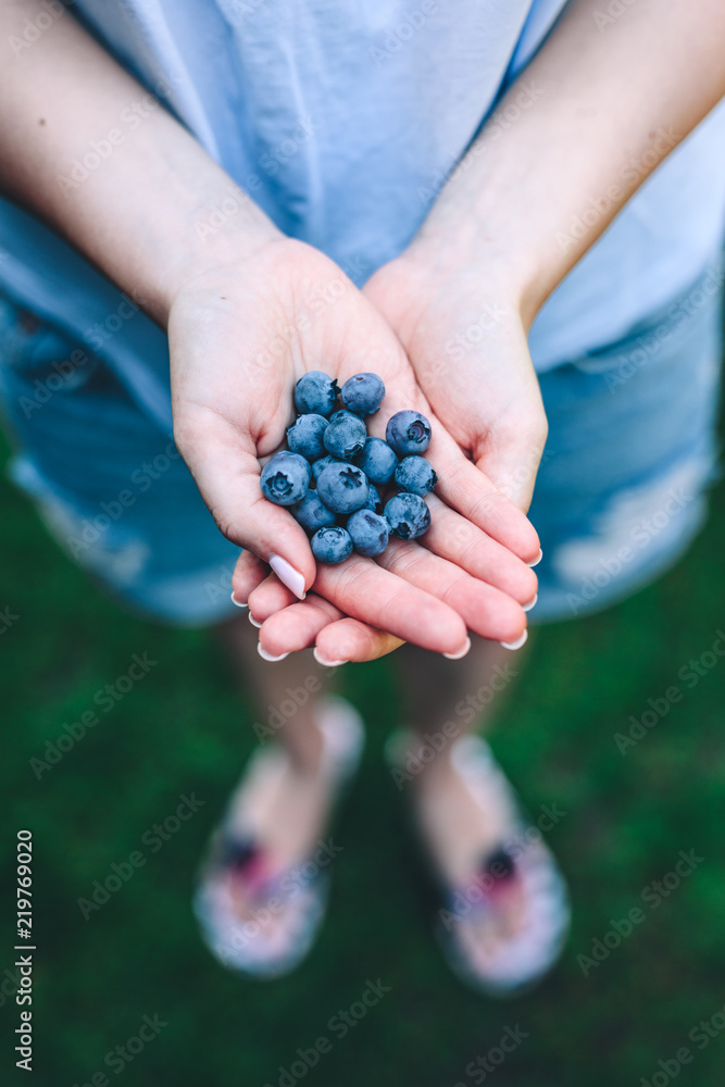 Woman holding blueberries in her hands