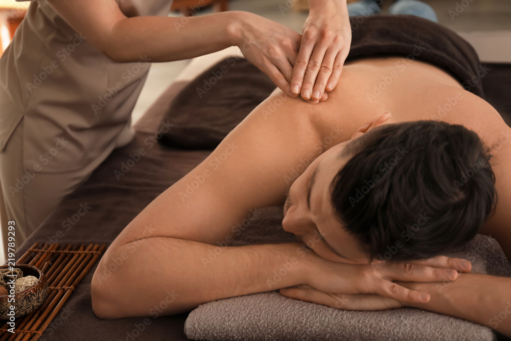 Young man receiving massage at spa salon