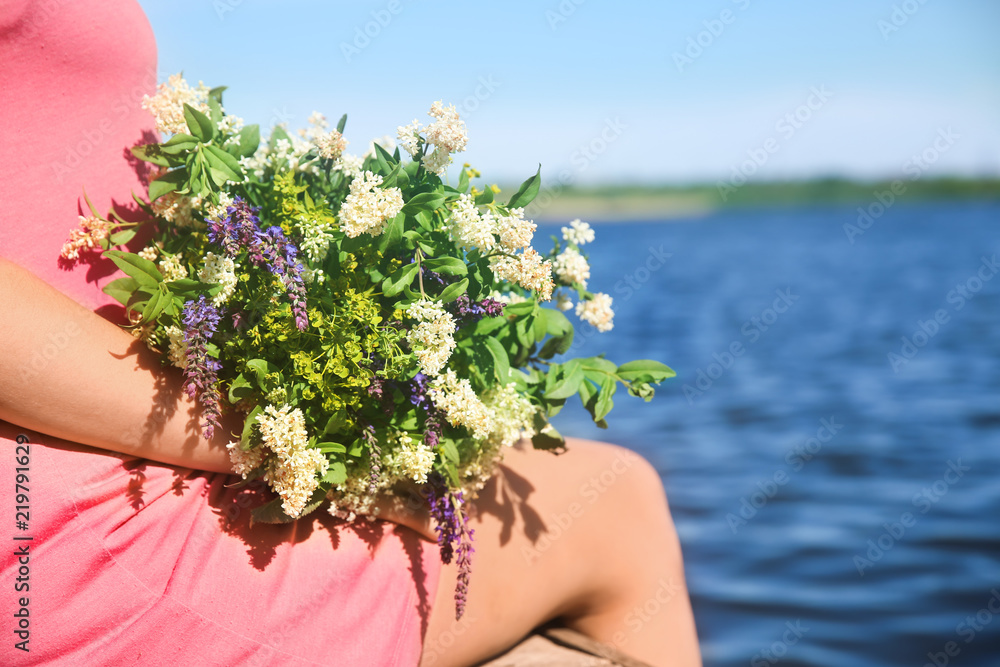 年轻女子在户外捧着一束美丽的鲜花