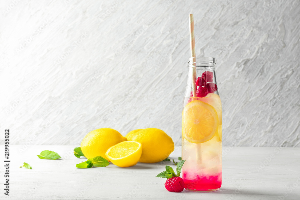 Bottle of fresh raspberry mojito on table