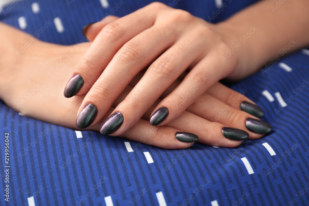 Hands of young woman with stylish manicure on cloth, closeup