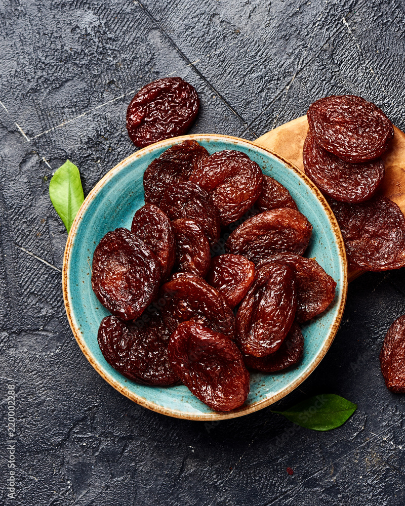 Dried brown apricots on gray background. Top view.