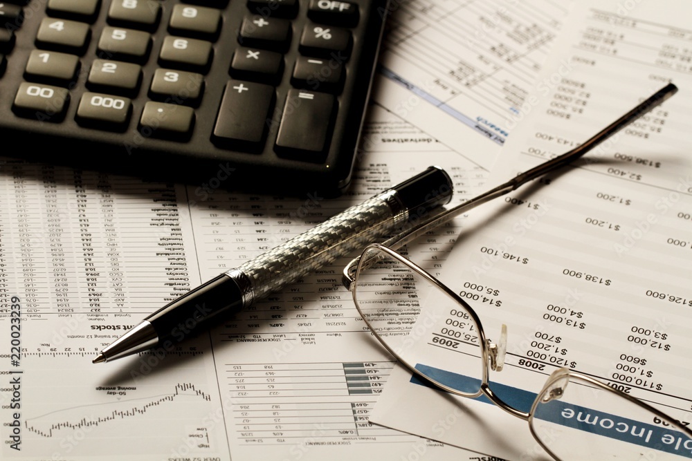 Pen, Glasses And Calculator On Financial Reports Close-up