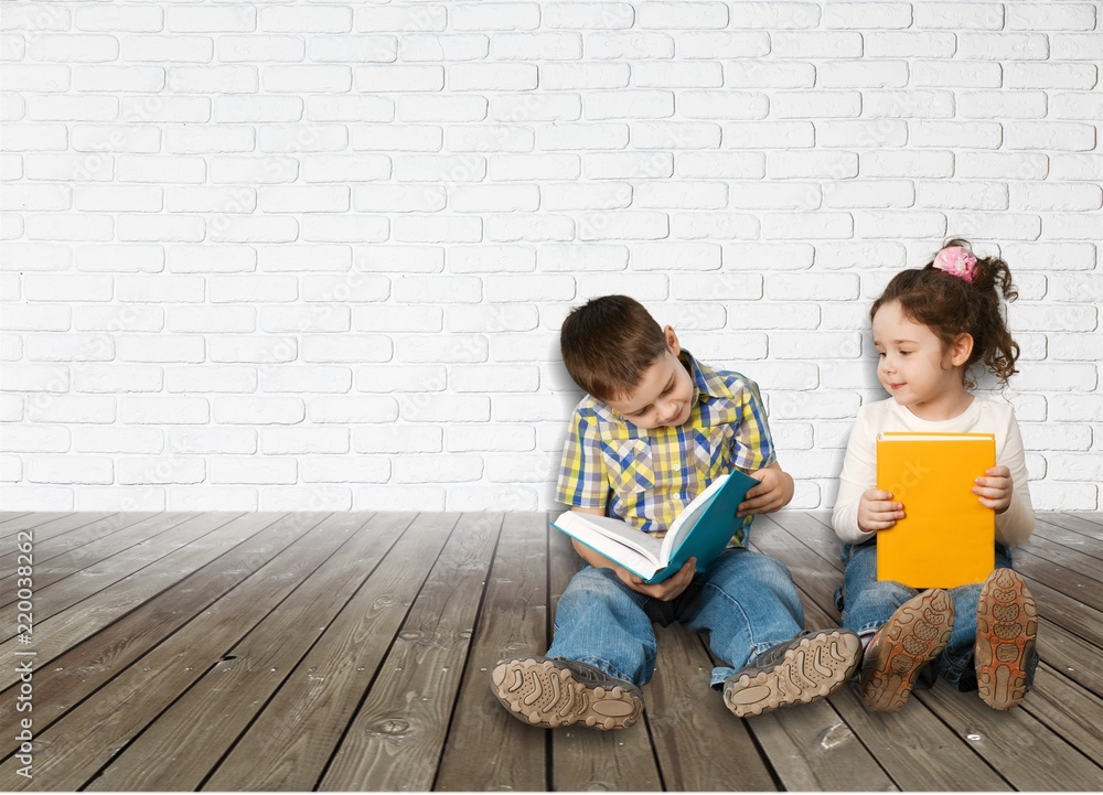 Two little kids reading while sitting