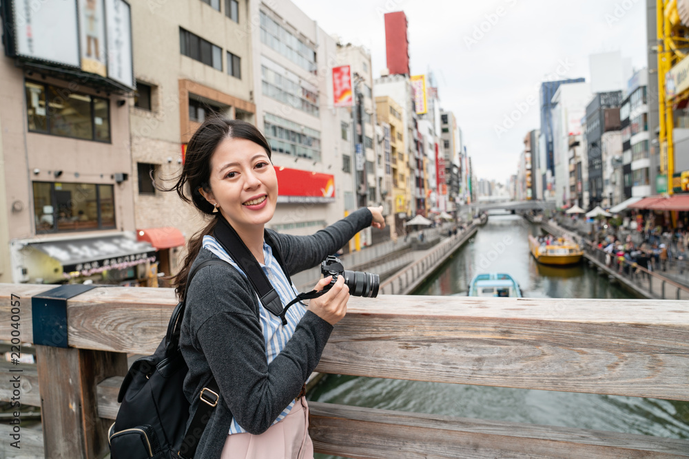 迷人的女人指着著名的地标。