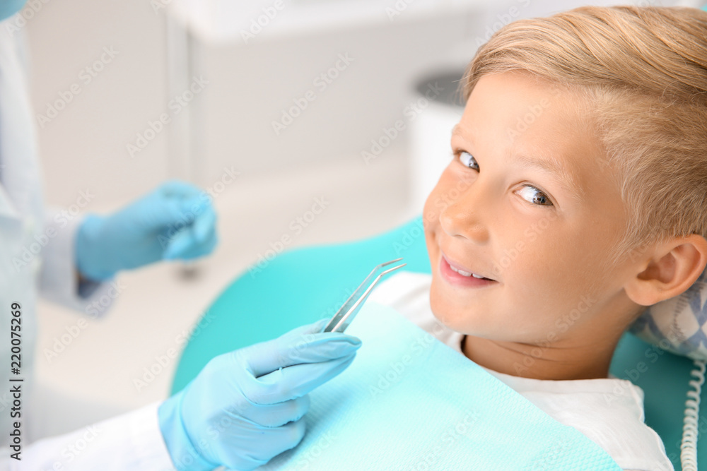 Dentist examining little boys teeth in clinic