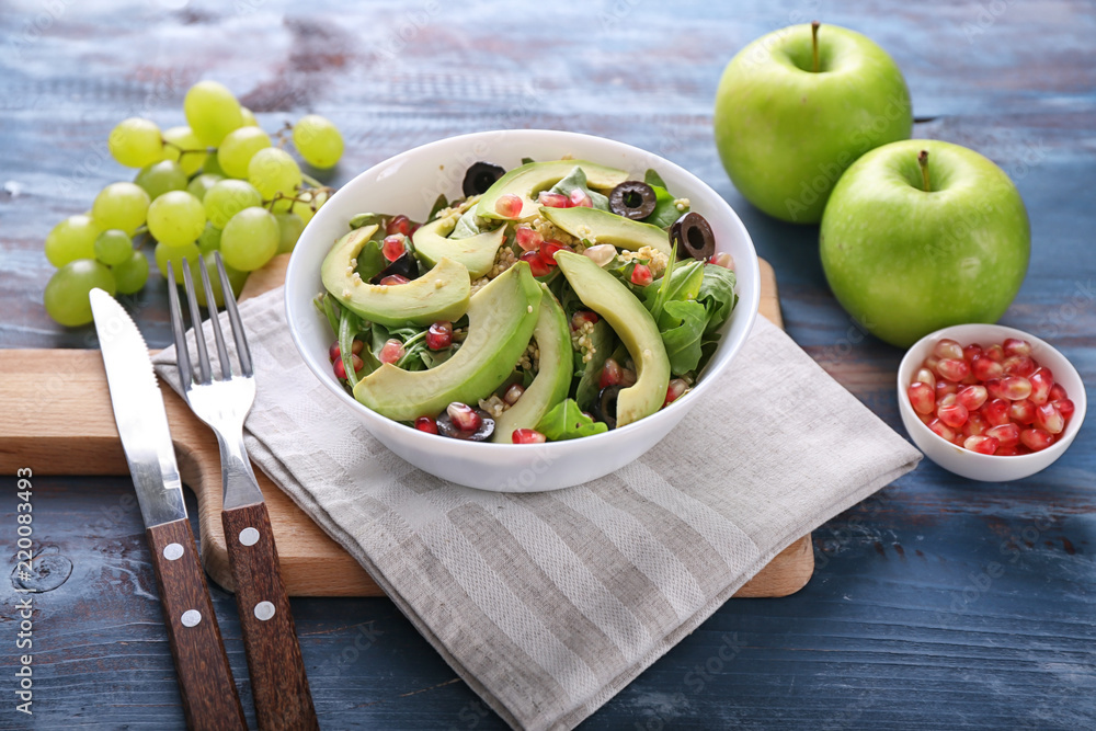 Plate with healthy fresh salad on wooden board