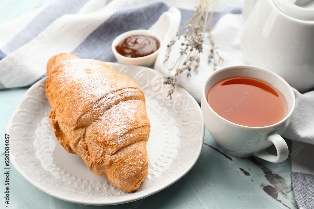 清淡的桌子上摆着美味的羊角面包和一杯茶