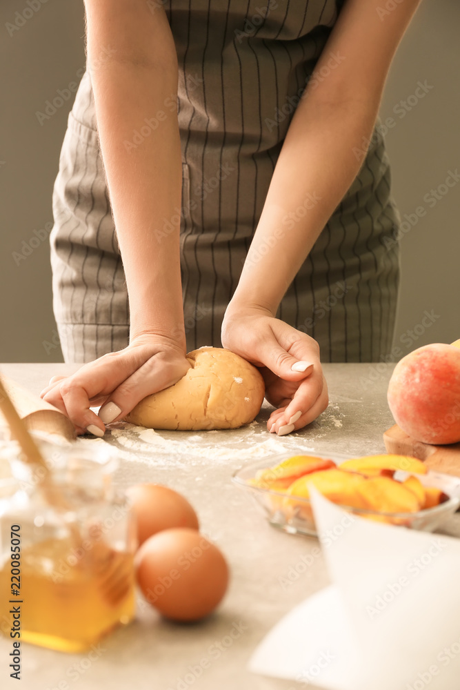 餐桌上的女人正在为桃卷准备面团