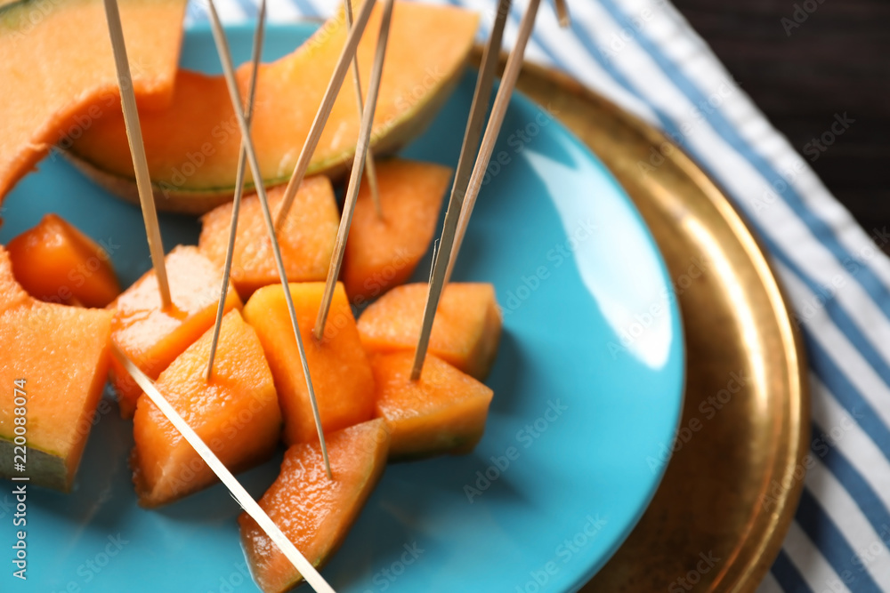 Plate with tasty cut melon on table, closeup