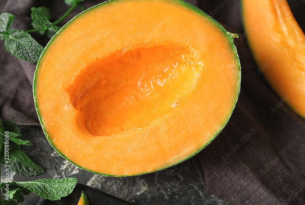 Half of tasty cut melon on table