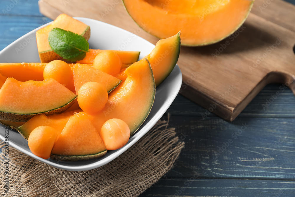 Bowl with cut ripe melon on table