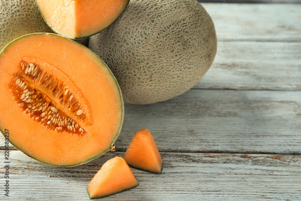 Tasty ripe melons on wooden table