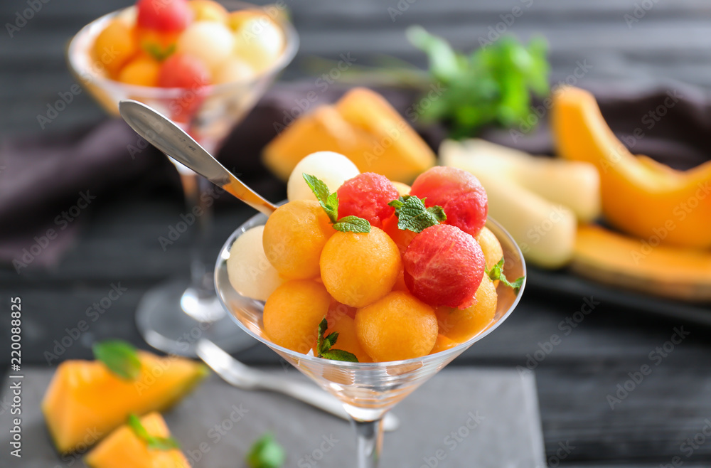 Glass with tasty melon balls on table, closeup