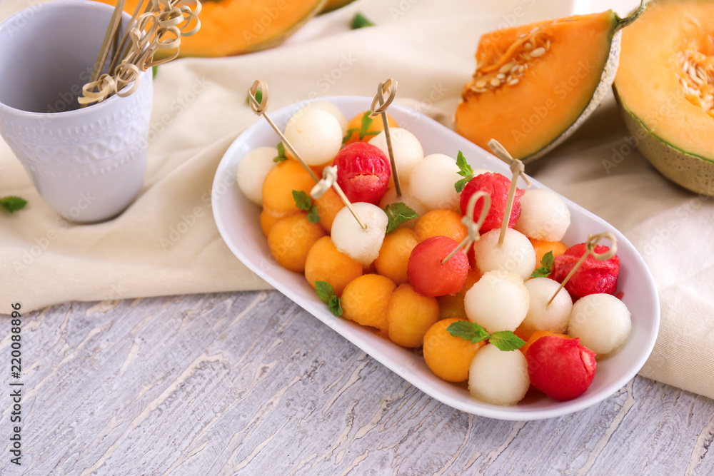 Plate with tasty melon balls on table