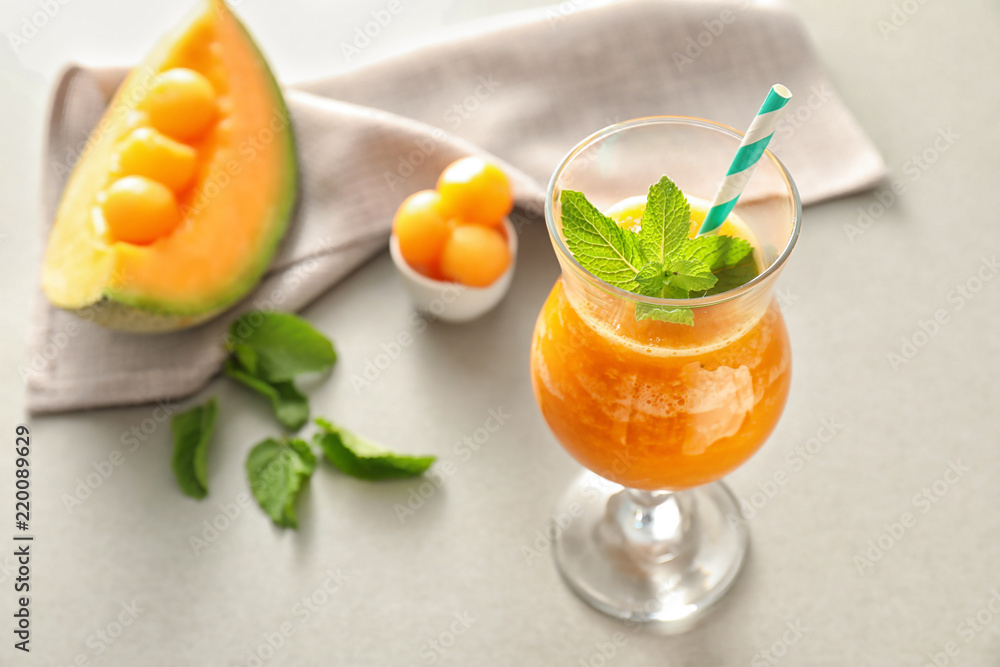 Glass of fresh melon smoothie on light table