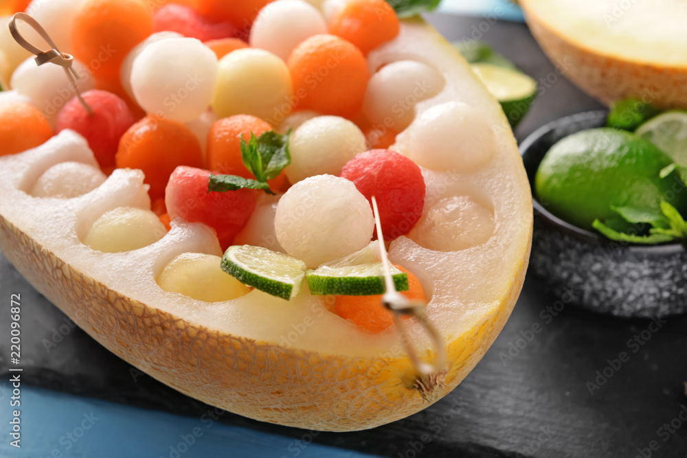 Half of melon with delicious balls on table, closeup