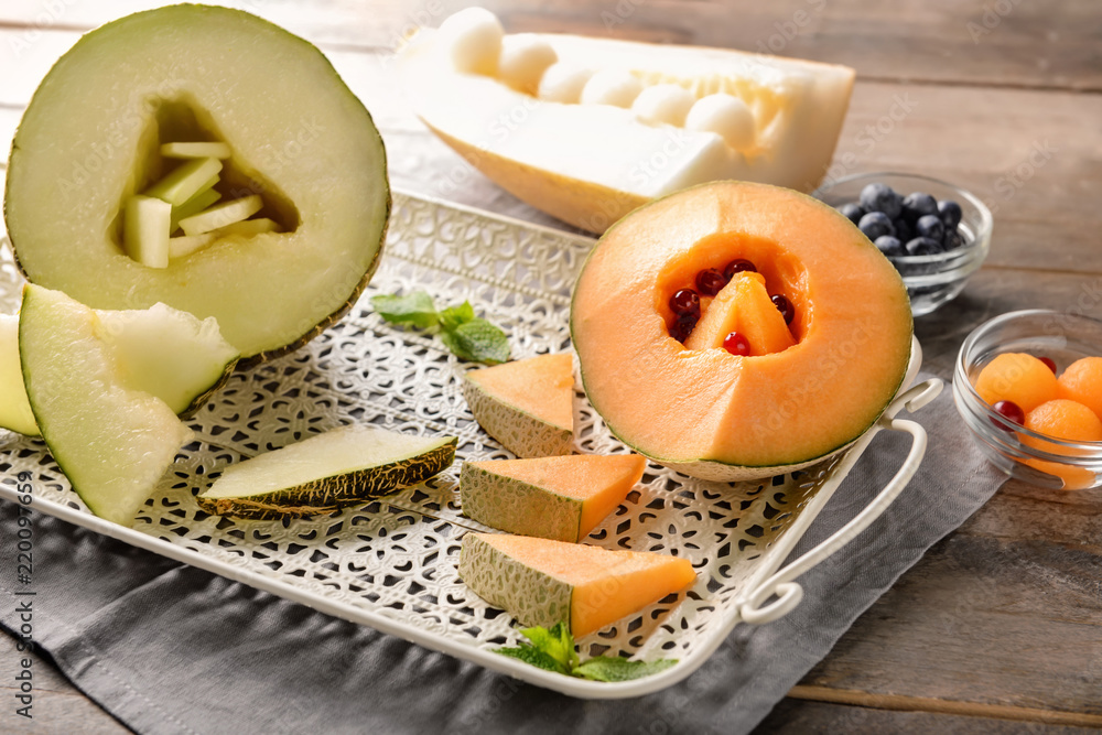 Tray with delicious melon on wooden table